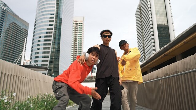 Group of handsome hipster standing while looking at camera with city view. Professional break dancer wear stylish cloth while moving or waving hands to hip hop music. Modern lifestyle. Sprightly.