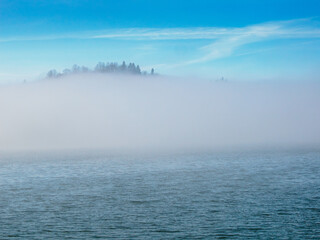 In the foreground, Lake Czorsztynskie and fog rising from the water. Czorsztyn. Poland.