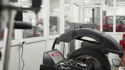 Auto mechanic mounts tire on changer. Professional tech uses machine for installation, balancing. Work in shop, focus on tools and rims. Vehicle maintenance service process displayed, automotive care.