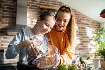 Mother and daughter making apple pie in the kitchen at home