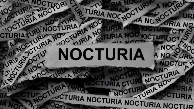 Strips of newspaper with the words Nocturia typed on them. Black and white. Close up.
