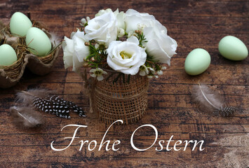 Grußkarte Frohe Ostern. Ostergruß mit Blumenstrauß und Ostereier auf rustikalen Holztisch.