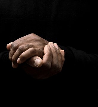 man praying to god with hands together on grey background with people stock image stock photo	