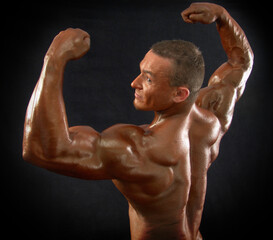 Portrait of a muscular male bodybuilder on a dark background.