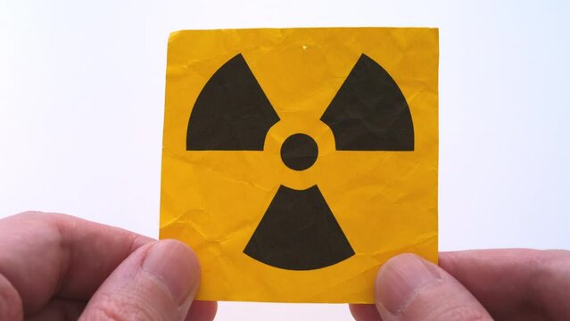 A man holding a radiation warning sign in his hands. Close up.