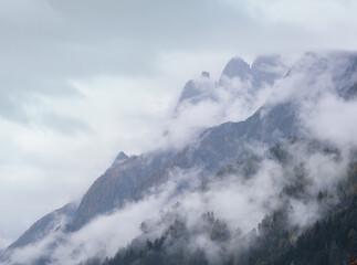 Fototapeta na wymiar Mystic cloudy and foggy autumn alpine mountain slopes scene. Austrian Lienzer Dolomiten Alps.