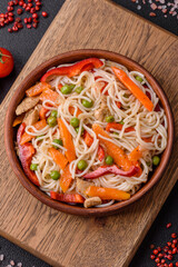 Delicious rice noodles or udon with chicken, carrots, pepper, salt, spices and herbs
