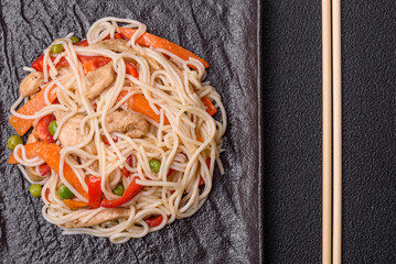 Delicious rice noodles or udon with chicken, carrots, pepper, salt, spices and herbs