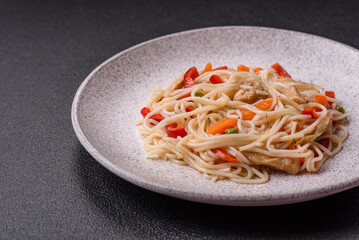 Delicious rice noodles or udon with chicken, carrots, pepper, salt, spices and herbs