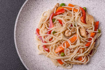 Delicious rice noodles or udon with chicken, carrots, pepper, salt, spices and herbs