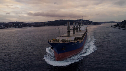 Aerial view of a large, loaded container cargo ship traveling over open ocea