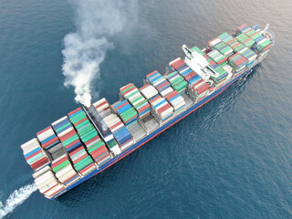 Aerial view of a large, loaded container cargo ship traveling over open ocea