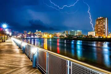 Wilmington skyline by night reflected in Christiana River, along Jack Markell boardwalk trail, during a lightning storm. Wilmington is the largest city in the state of Delaware. - 760064939