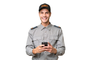 Young security man over isolated background sending a message with the mobile