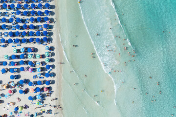 Aerial view on beach, people and umbrellas. Vacation and adventure. Top view from drone at beach and azure sea. View on the coast from drone. - 760080749