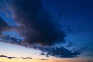 Dark clouds during sunset. Blue sky. Sunshine. A huge clouds in the sky after a storm. Natural landscape. Wallpaper and background. - 760081552