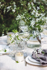 Rustic elegant eco friendly zero waste trendy wedding reception table decor with fresh spring apple cherry flowers in bloom. Beautiful marriage decoration, holiday event outdoors in the family garden