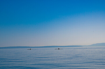 Beautiful sea with horizon. Two kayaks are floating in the distance