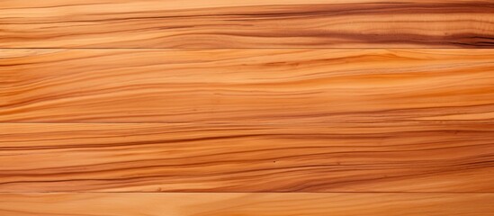A closeup of a brown hardwood surface with warm amber and orange tints, showcasing the beauty of wood stain and varnish on the flooring