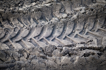 Tractor wheels imprint in raw soil. Textured abstract background