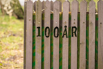 100 years carved out on a fence.
