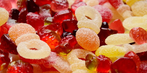 Lots of colorful candies made of jelly and various fruits, background and texture	