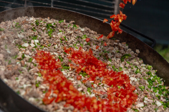 Tomato Tossing in Traditional Discada Preparation