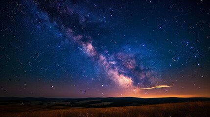 Naklejka na ściany i meble The serene landscape under a rich star-filled sky with a hint of the Milky Way's presence
