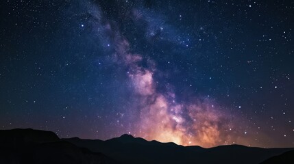 Fototapeta na wymiar A breathtaking view of the Milky Way stretching above silhouetted mountains under the dark night sky