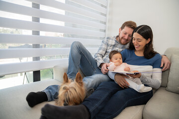 Portrait of a family that reflects the union and solidarity, where the father tells a story to his baby and wife