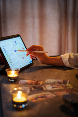 Girl numerologist makes a map of codes for the future on a tablet. Veritcal photo. 