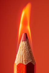 close-up photography of red graphite wooden pencil on light red background with a flame on a top