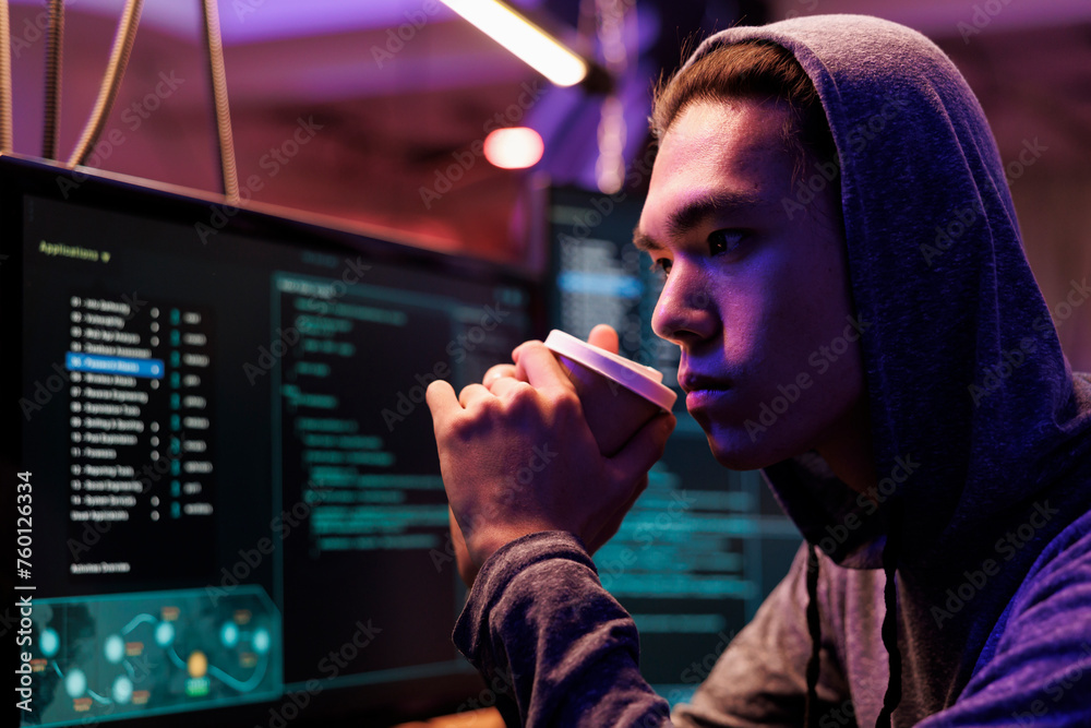 Poster asian hacker drinking coffee and breaking into database using spyware. criminal sipping beverage and