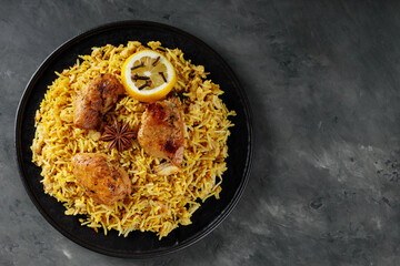 Chicken Biryani with Spices on Black Plate, Indian Cuisine Concept, Top View, Copy Space