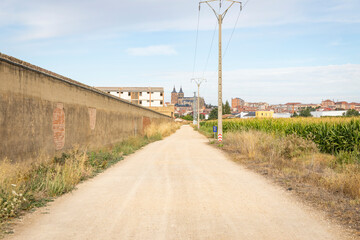 Fototapeta na wymiar French Way of Saint James - a gravel road with a view of Astorga city, province of Leon, Castile and Leon, Spain