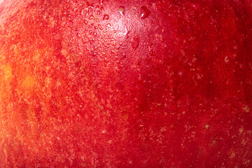 The texture of an apple is red with yellow. Apple skin with water drops.