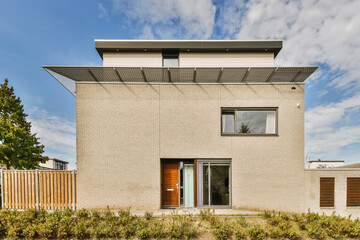 Modern two-story house with a flat roof and garden