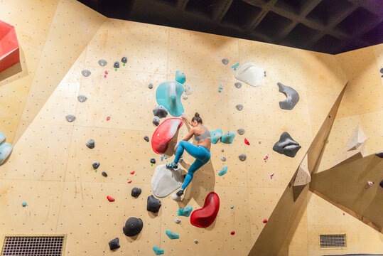 Active woman conquering an indoor bouldering wall