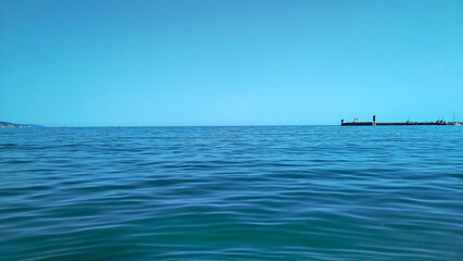 An ideal serene seascape - on the distant horizon the blue clear sky and the blue calm sea...