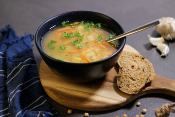 Close up of vegetarian yellow peas soup in bowl with slices of olive bread