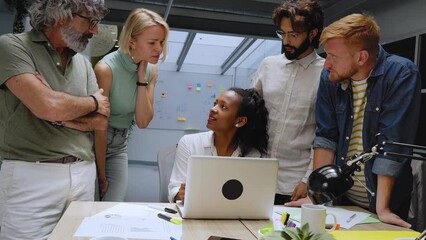 Diverse team of business professionals gathered in office conference room. Creative group around table female leader. Colleagues talk marketing campaign, social media strategy. People modern workplace - Powered by Adobe
