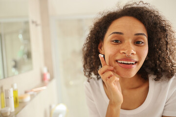 The woman with long hair brushes her teeth happily in front of the mirror