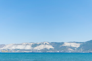 Sea horizontal landscape - blue sky, blue sea, mountain hills on the horizon