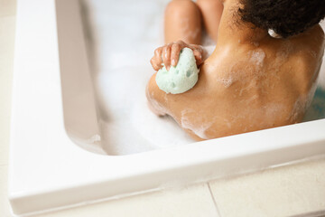 Fototapeta premium Woman bathing baby with sponge, creating a sculpture of care and love