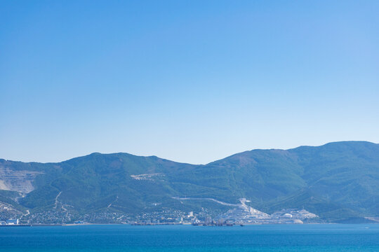 Sea horizontal landscape - blue sky, blue sea, mountain hills on the horizon