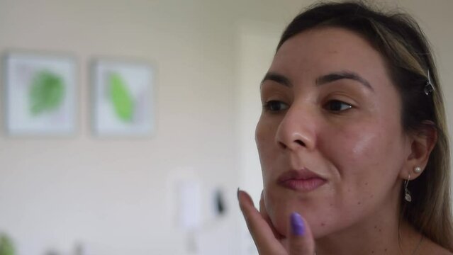 close-up woman putting on makeup in front of a mirror