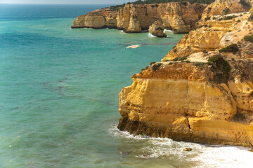 Fototapeta na wymiar Natural caves and beach, Algarve Portugal. Rock cliff arches of Seven Hanging Valleys and turquoise sea water on coast of Portugal in Algarve region