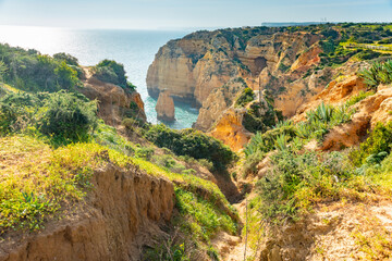 Natural caves and beach, Algarve Portugal. Rock cliff arches of Seven Hanging Valleys and turquoise...