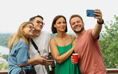 a group of friends relaxing in the city taking a selfie watching a video