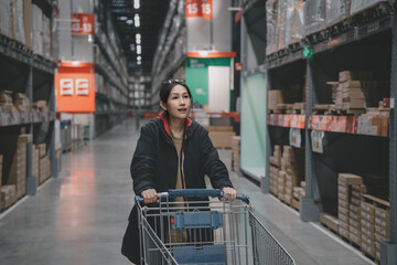 Young Woman Shopping in Warehouse with Cart